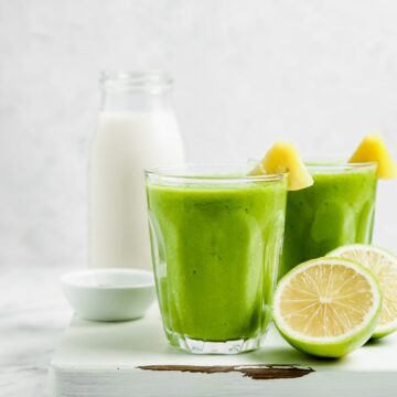 Two mango protein smoothies with a white background.