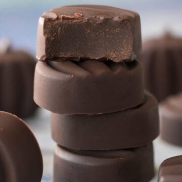 Homemade vegan dark chocolate candies stacked on top of each other.