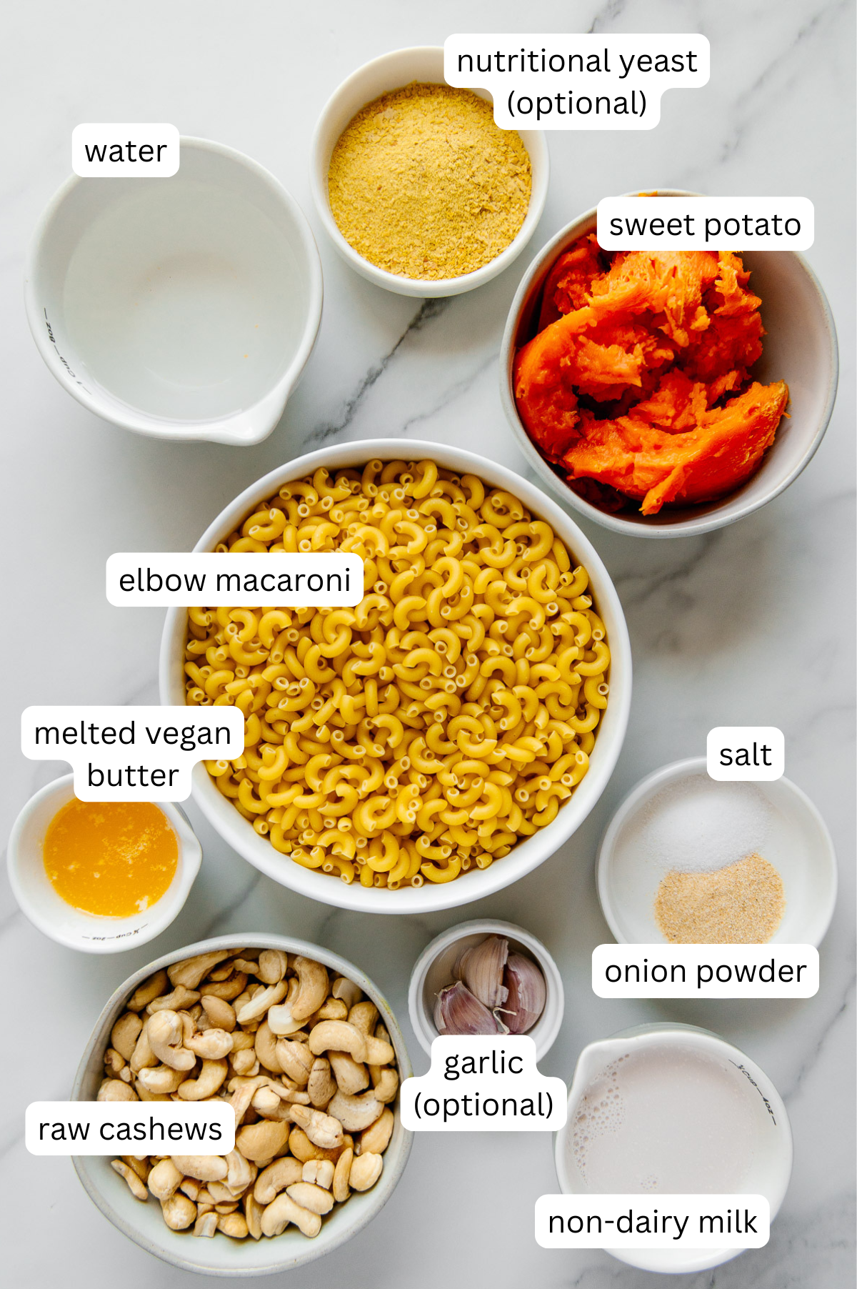 Ingredients for vegan mac and cheese with a white marble background.