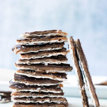 Stack of chocolate matzo crack with a light blue background.