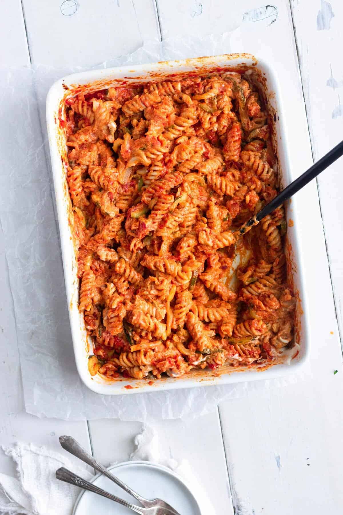 Vegan pasta bake in a white oven dish with a white background.