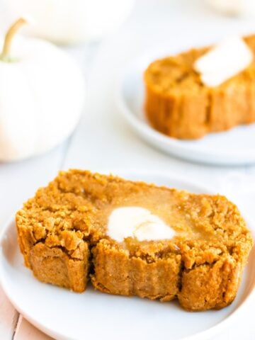 slice of pumpkin bread with butter and white pumpkin in background