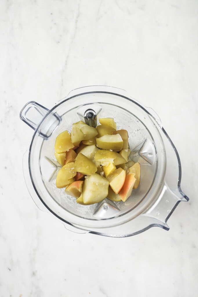 Chopped cooked potatoes in a clear blender bowl, viewed from above on a white marble surface—perfect for pairing with homemade Instant Pot applesauce.
