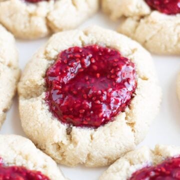 Vegan raspberry thumbprint cookies on a white countertop.