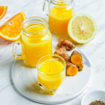 Lemon ginger turmeric shots with a white background.