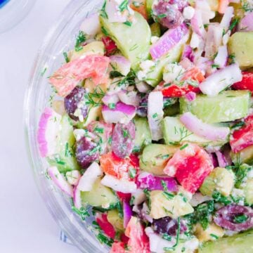 Greek cucumber salad on a white salad plate.