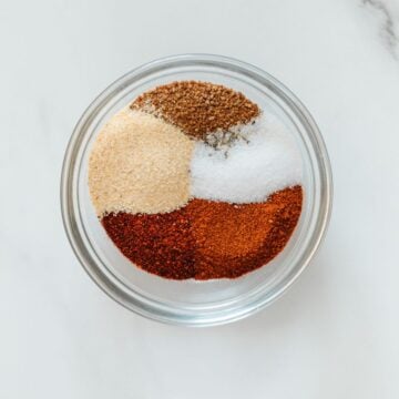 Homemade BBQ seasoning ingredients in a glass bowl before being whisked together.