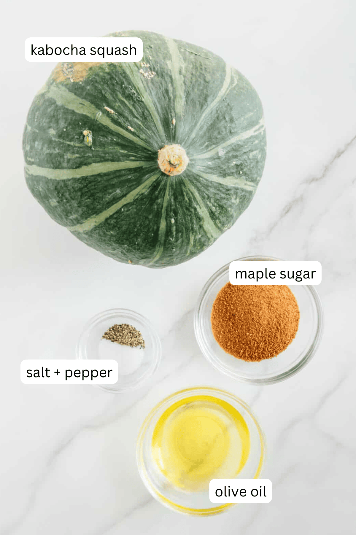 Kabocha squash recipe ingredients consisting of a whole kabocha squash, maple sugar, olive oil, salt and pepper.
