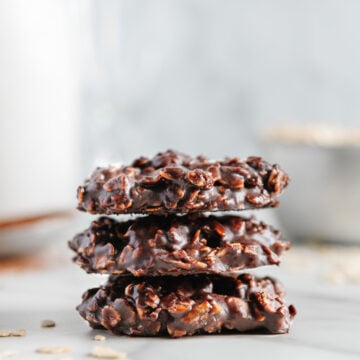 Three chocolate no-bake vegan cookies stacked on top of each other.