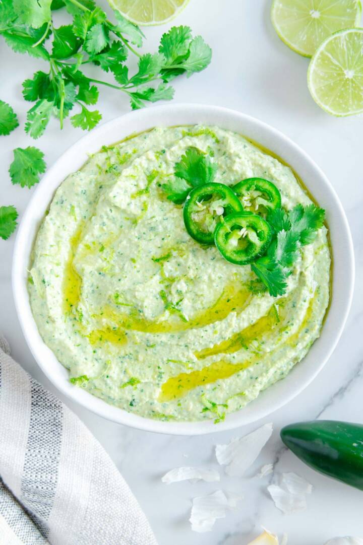 Cilantro jalapeno hummus in a white bowl.
