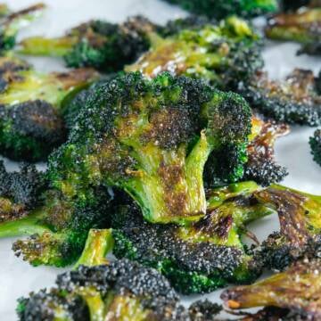 Smashed broccoli chips with a white background.