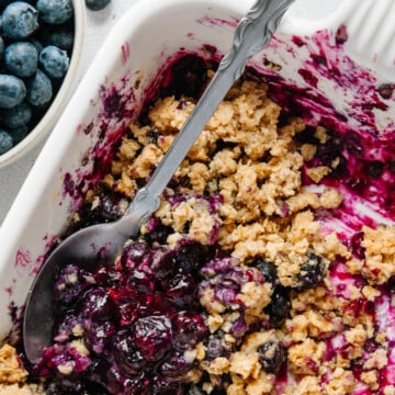 Gluten-free blueberry crisp in a white baking dish.
