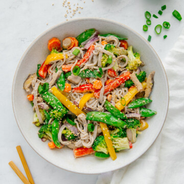 Vegan stir fry in a white bowl with a white background.