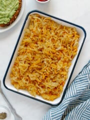 Crispy air fryer hash browns on a white platter with a blue rim.