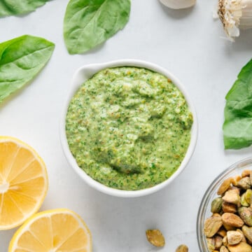 Pistachio pesto in a white bowl with a white background.