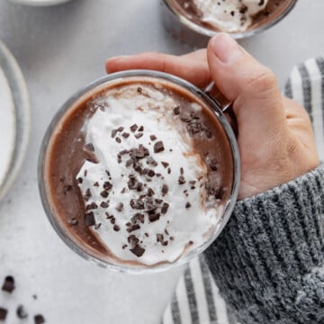 A hand holding a mug of protein hot chocolate