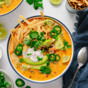 Vegan tortilla soup topped with crispy tortilla strips, jalapeño, cream, avocado and lime
