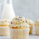 Vegan Vanilla White Sweet Potato Frosting on cupcake with sprinkles and milk in background