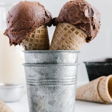 Two cones of no-churn vegan chocolate ice cream in a silver container.
