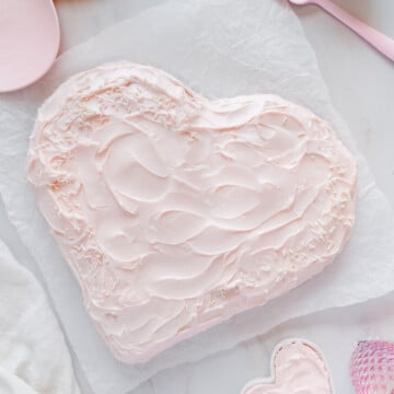 A heart-shaped cake covered with pink frosting.