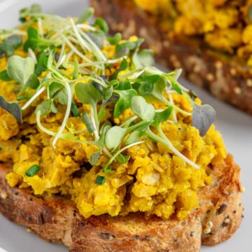 Chickpea scramble on toast on a white plate.