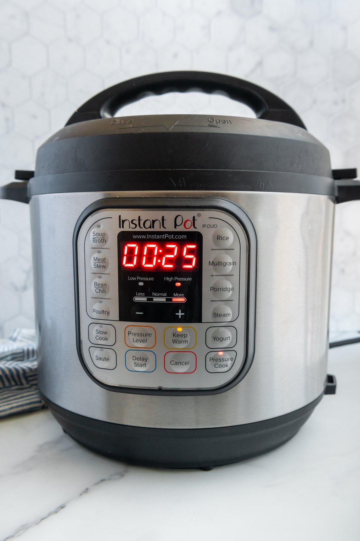 An Instant Pot set to cook black beans on a white counter.