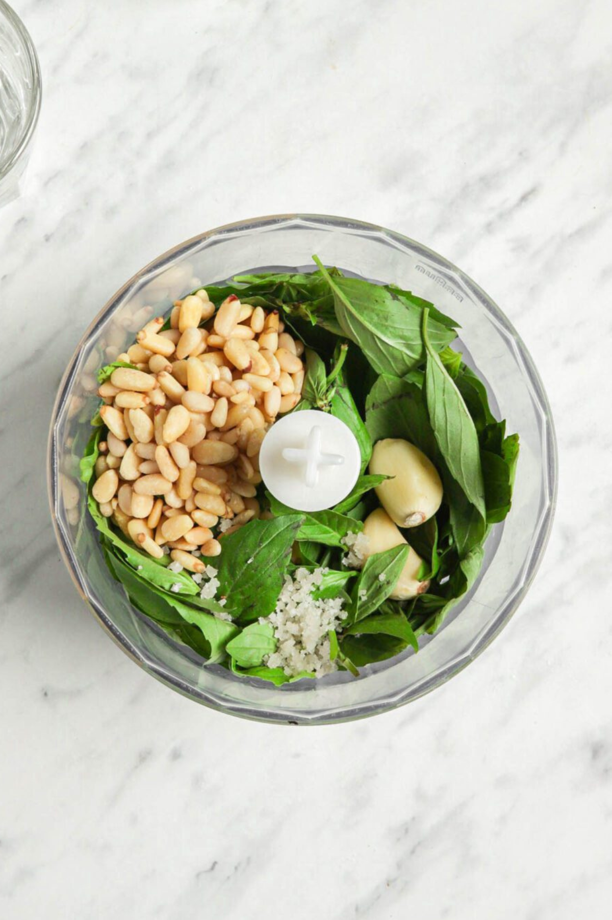 Pesto ingredients in a food processor.