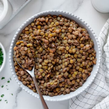 Cooked Green Lentils in Bowl with serving spoon