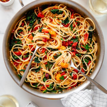 Meghan Markle's One-Pot Pasta in a large pot with two forks with spaghetti twirled around each with a white background.