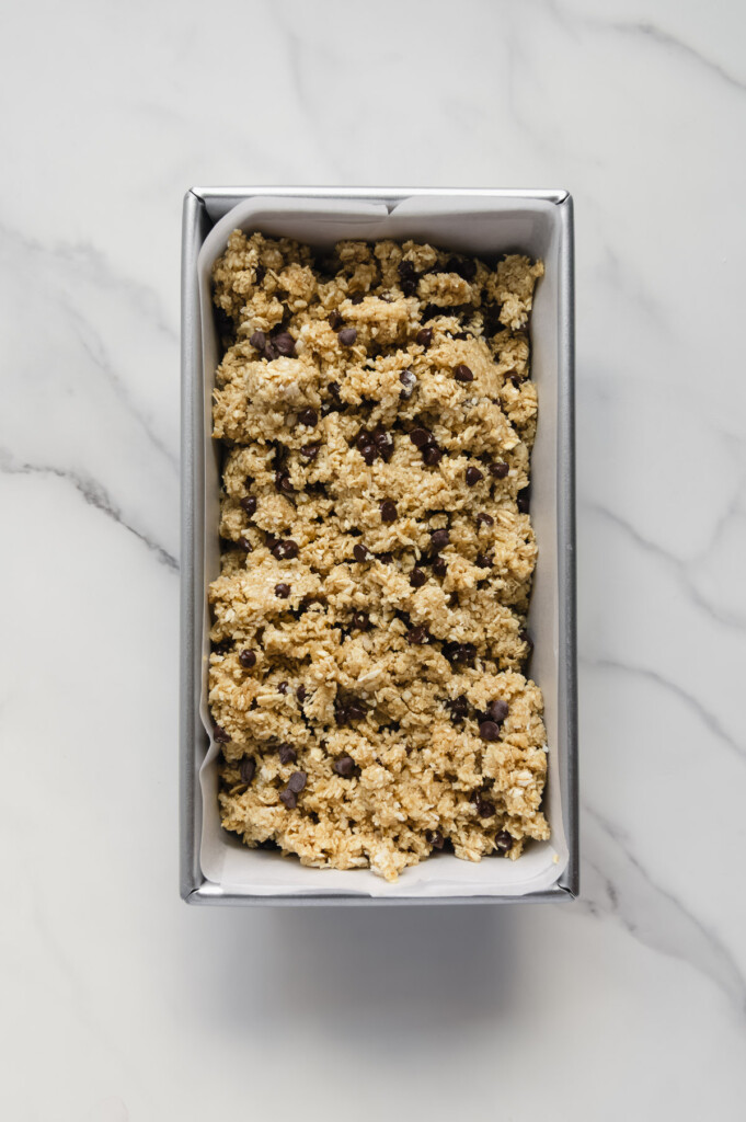 Homemade Healthier Hunks mixture in a loaf pan with a white marble background.
