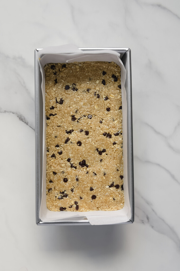 Homemade Heavenly Hunks mixture packed into a loaf pan with a white marble background.