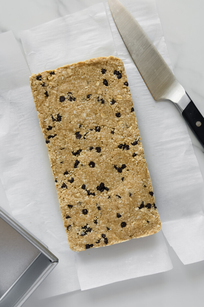Homemade Heavenly Hunks mixture after freezing and before slicing into chunks on white parchment paper.
