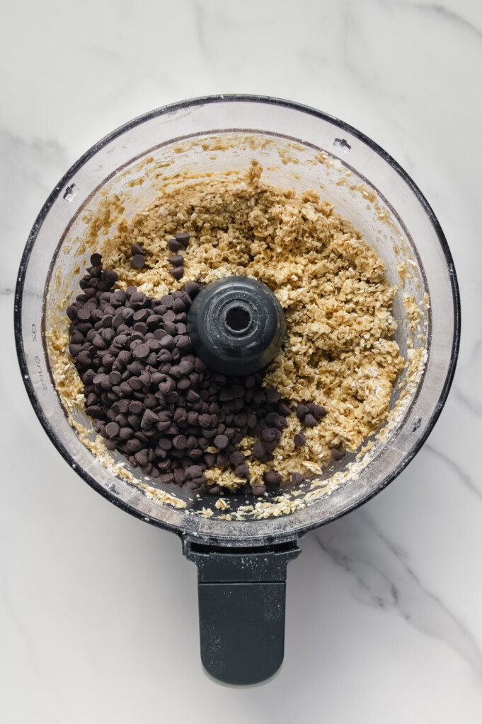 Chocolate chips added to homemade Healthier Hunks mixture in a food processor.