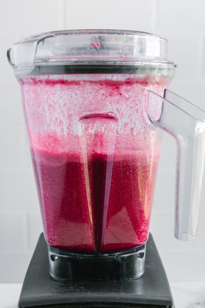 Fruit punch in a blender after blending with a white background.