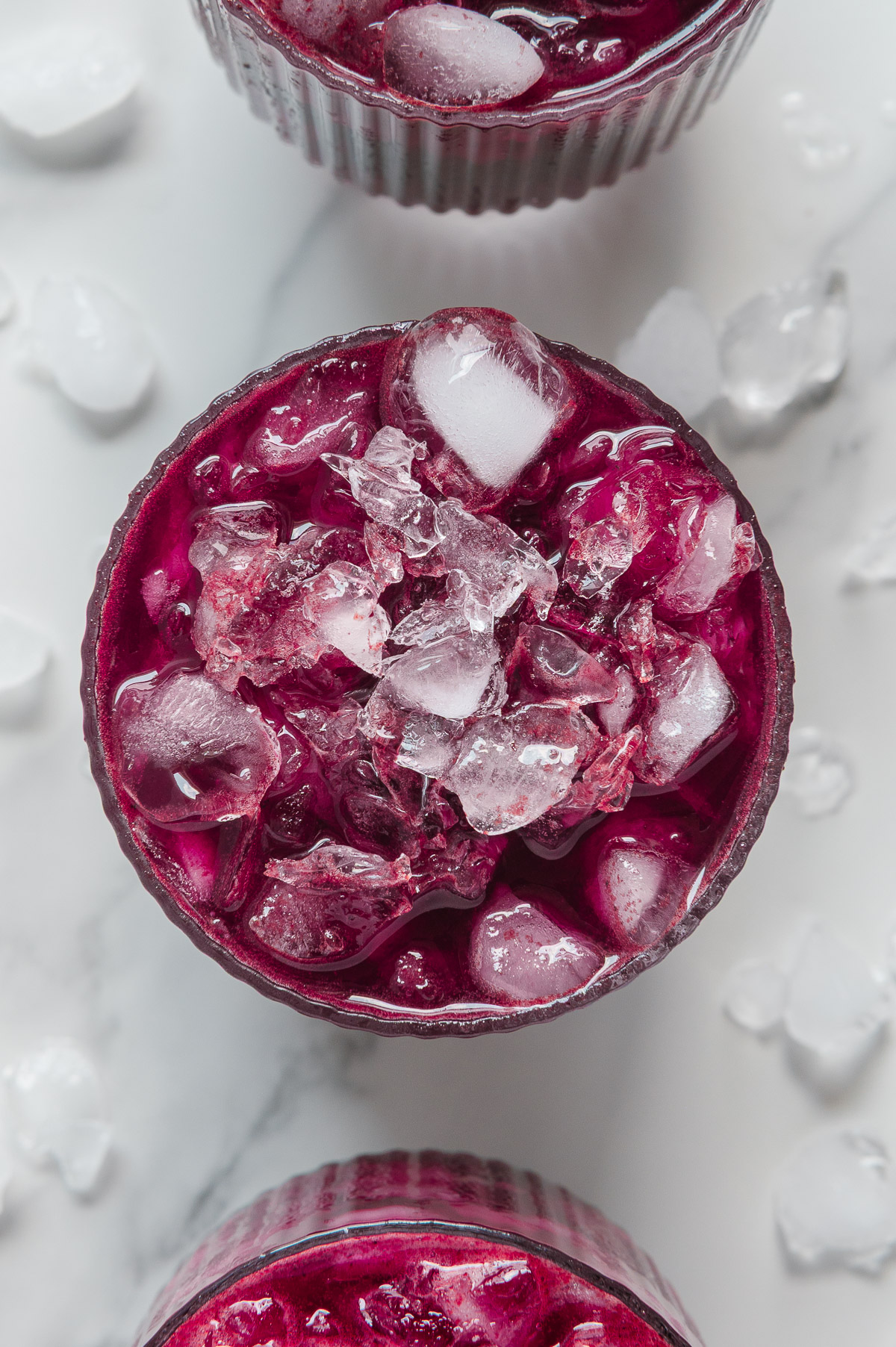 Blueberry Lemonade Recipe overhead shot with crushed ice in glass and on background
