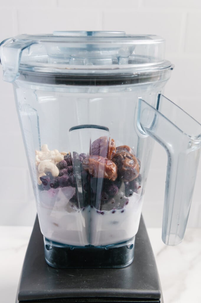 Healthy blueberry milkshake ingredients in a blender prior to blending.