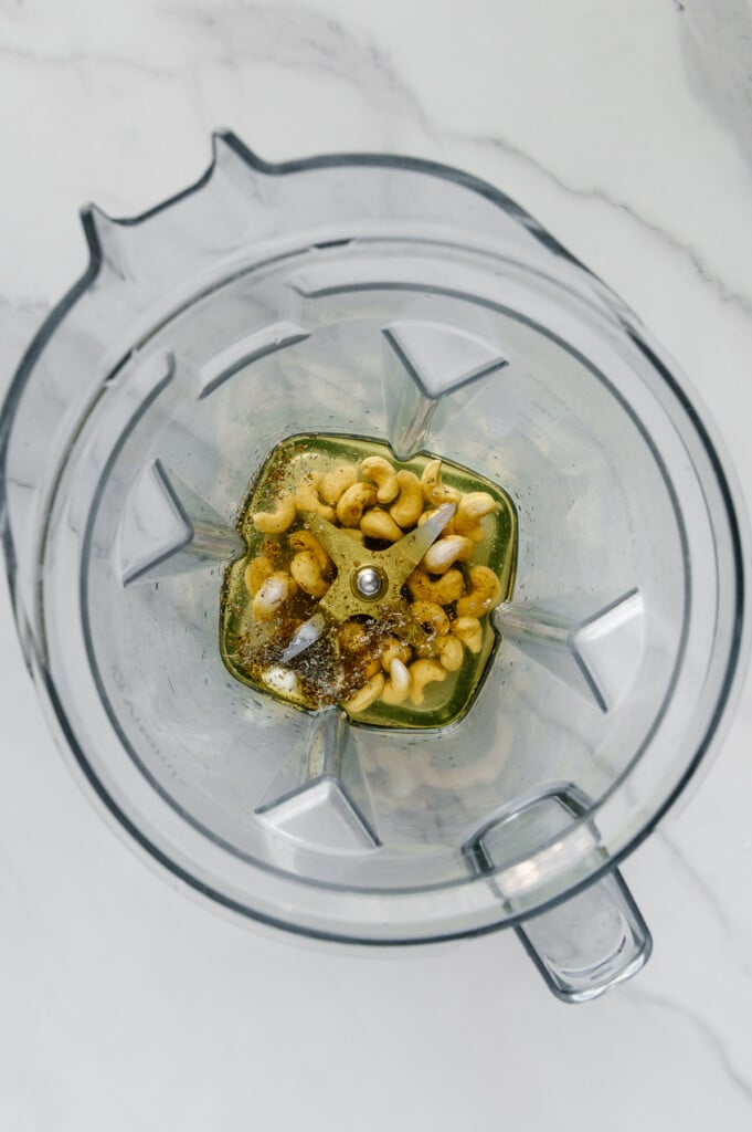 Cashews, olive oil and seasonings in a blender prior to blending.