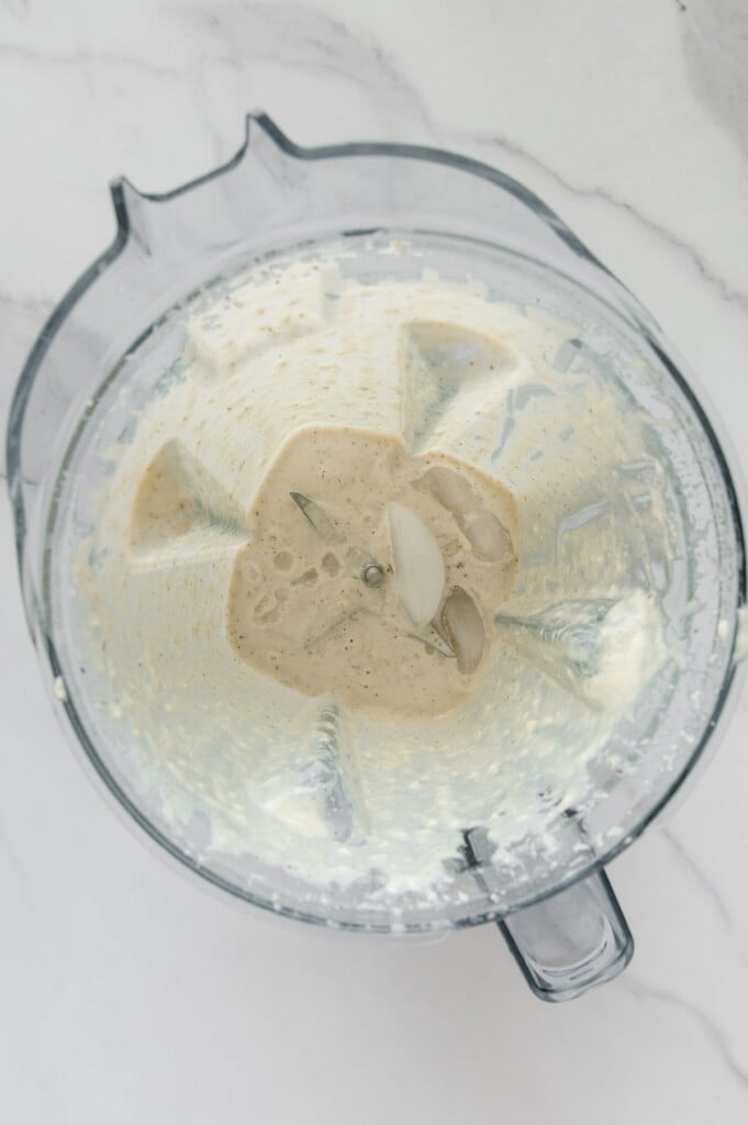 Vegan Italian dressing in a blender with ice cubes added.