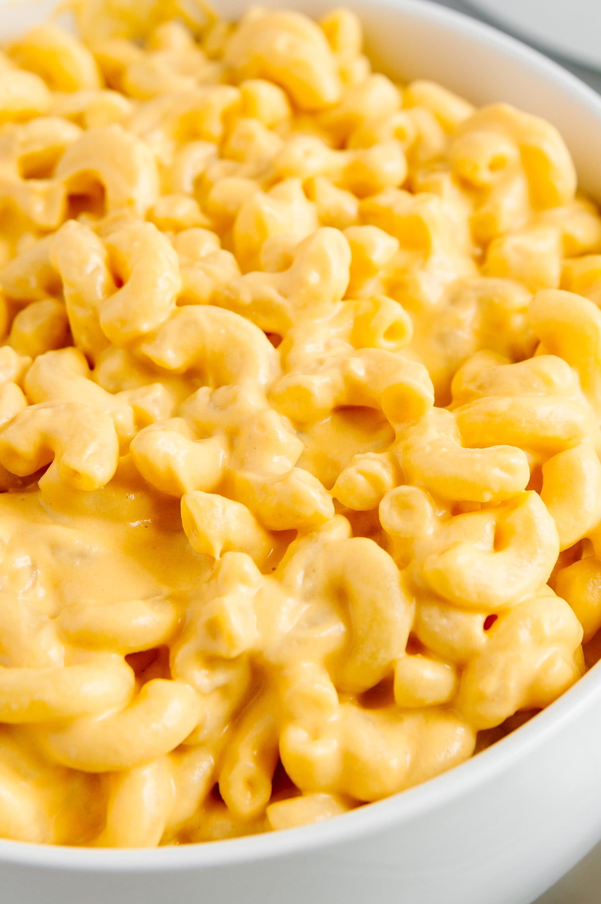 A close up shot of vegan mac and cheese in a white bowl.