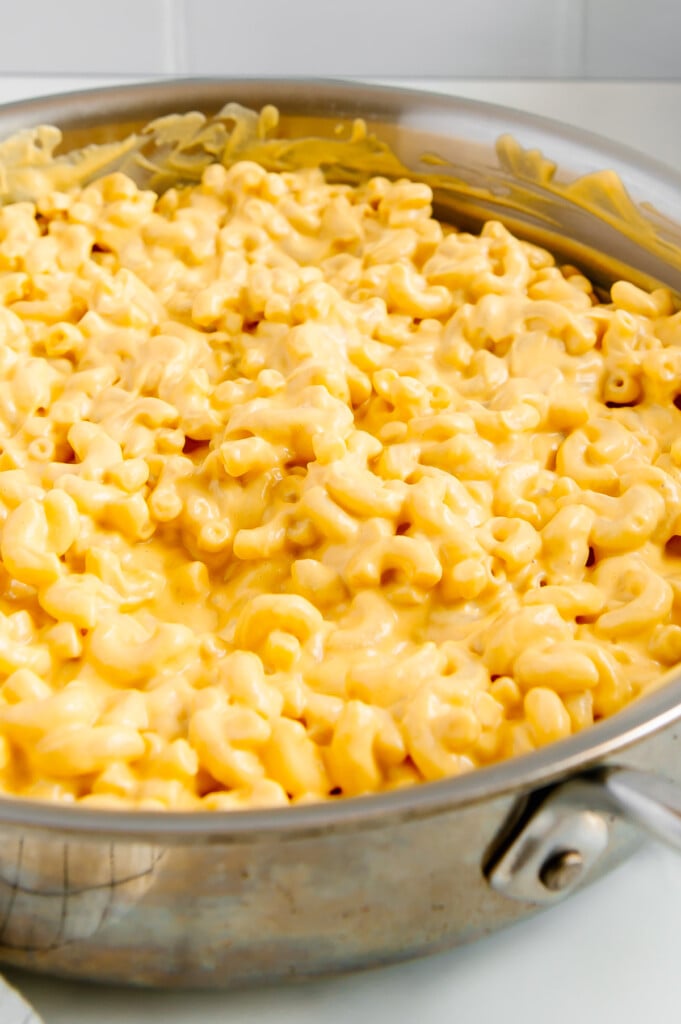 Vegan mac and cheese in a silver pot with a white background.