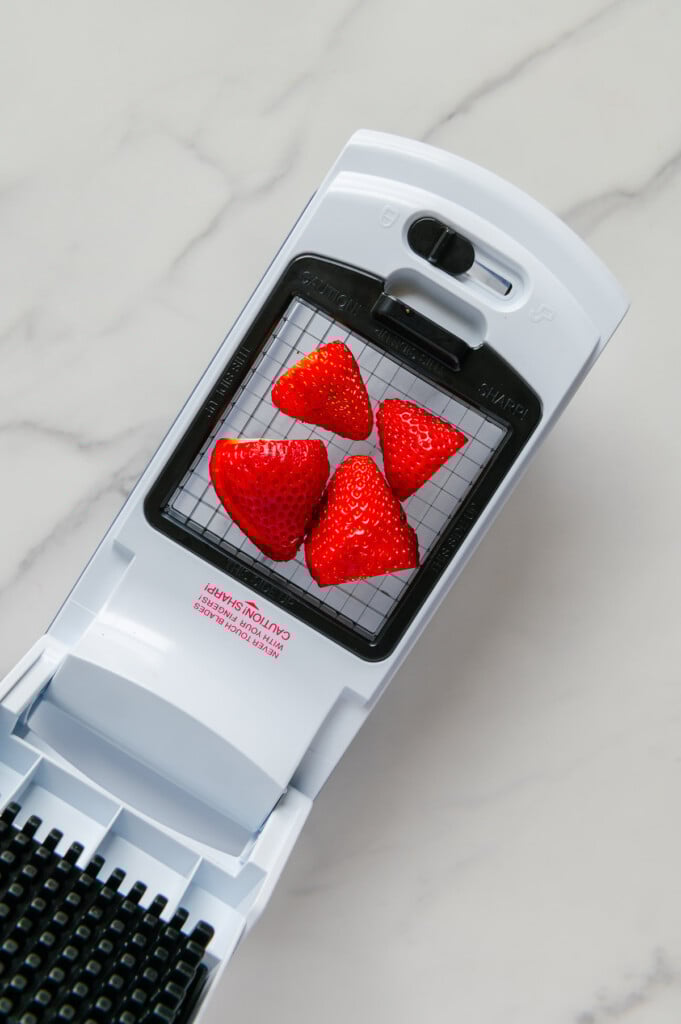 Four strawberry halves on a veggie chopper prior to being chopped.