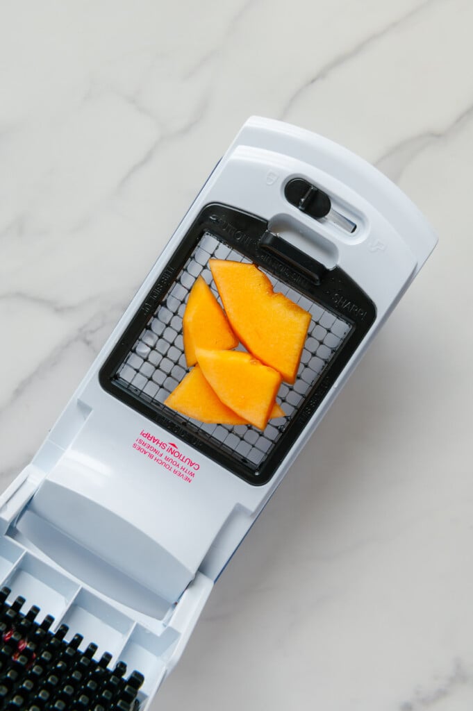 Cantaloupe pieces in a veggie chopper prior to being chopped.