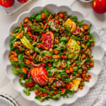 Fall harvest salad in a white bowl with a white marble background.