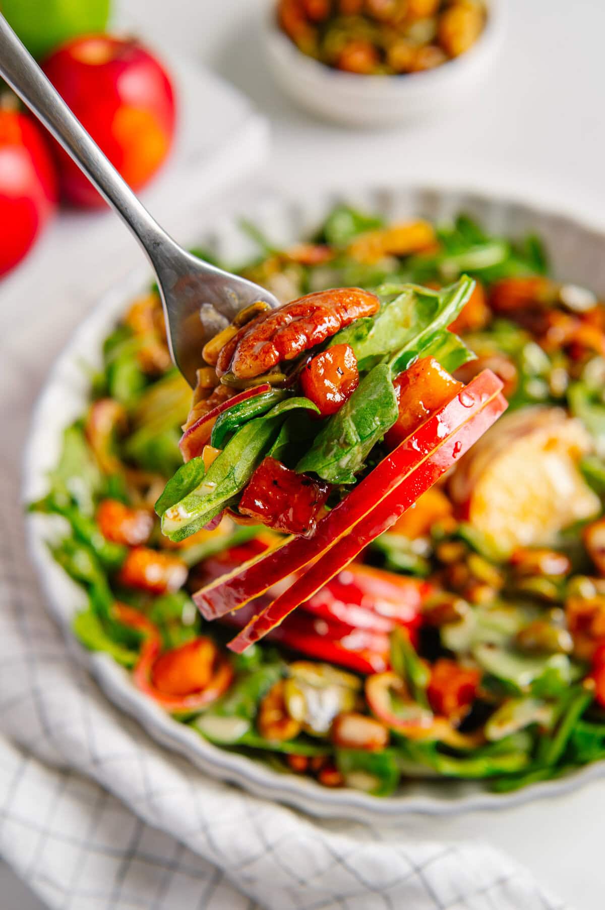 A bite shot of a vegan fall harvest salad above the bowl of the salad.