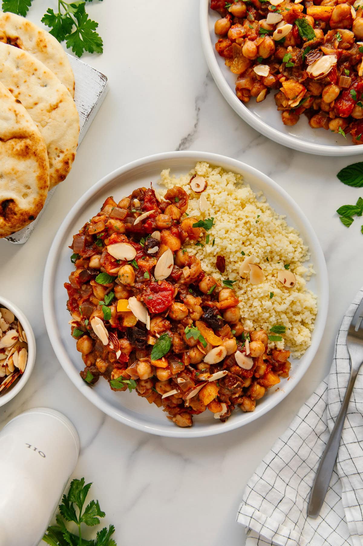 Moroccan chickpeas served with cous cous with a white marble background.