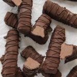 Homemade 3 Musketeers bars arranged on a white background with some sliced in half to see the filling.