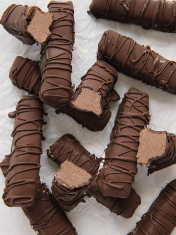Homemade 3 Musketeers bars arranged on a white background with some sliced in half to see the filling.