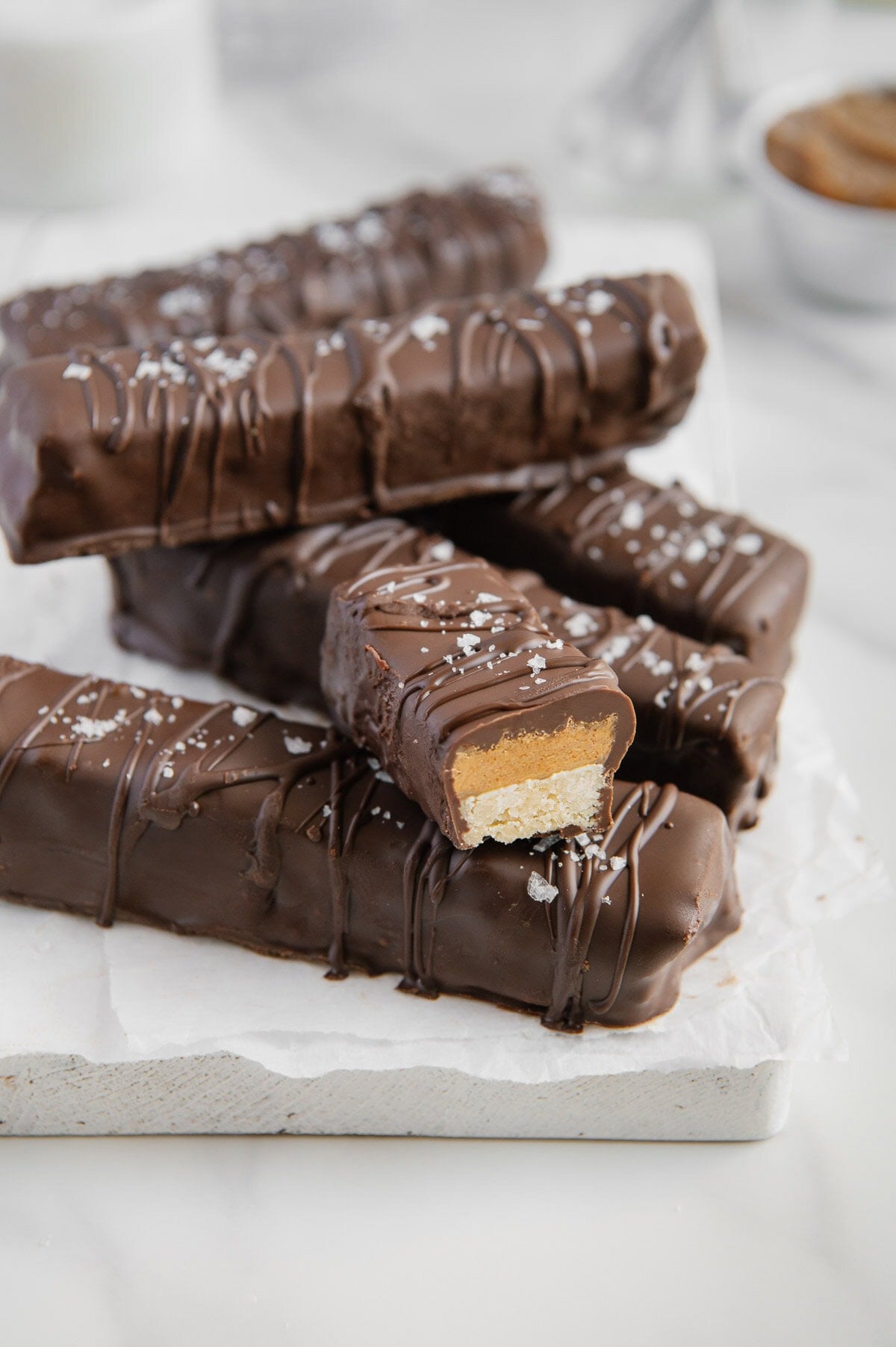 Homemade Twix bars stacked on top of each other with a white background.