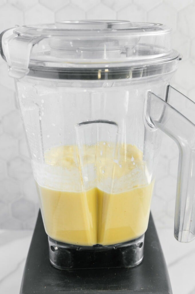 A ginger smoothie in a blender after blending.