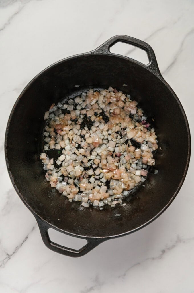 Sautéed shallots in a cast iron skillet.